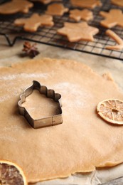 Photo of Making homemade Christmas cookies. Dough and cutter on table, closeup