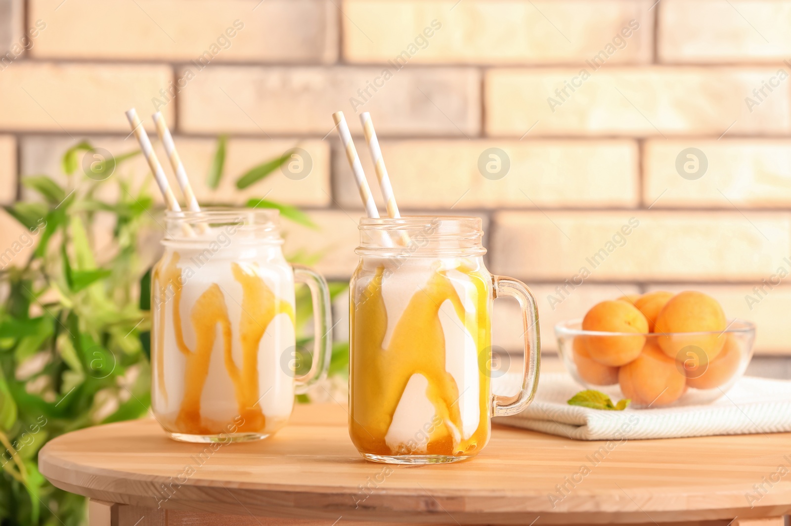 Photo of Mason jars with delicious milk shakes on table