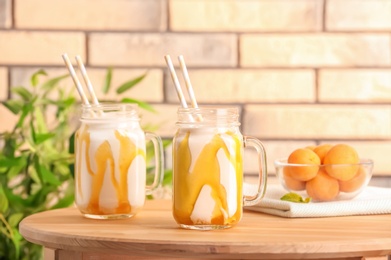 Mason jars with delicious milk shakes on table