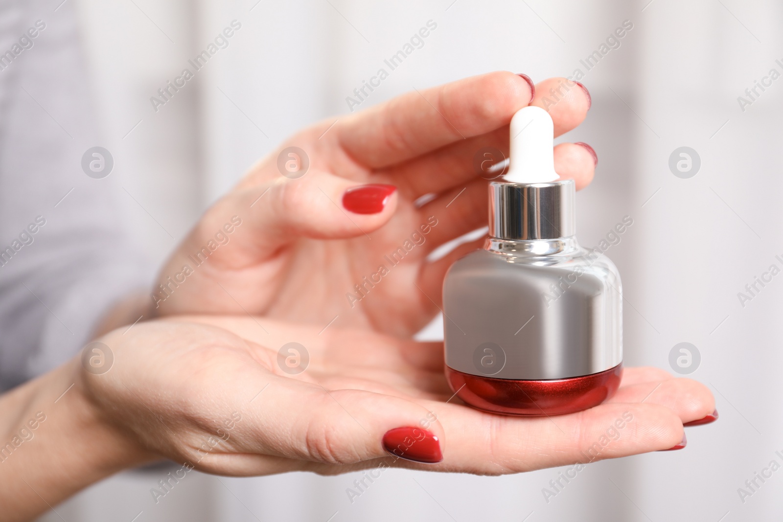 Photo of Woman holding cosmetic product, closeup. Winter care