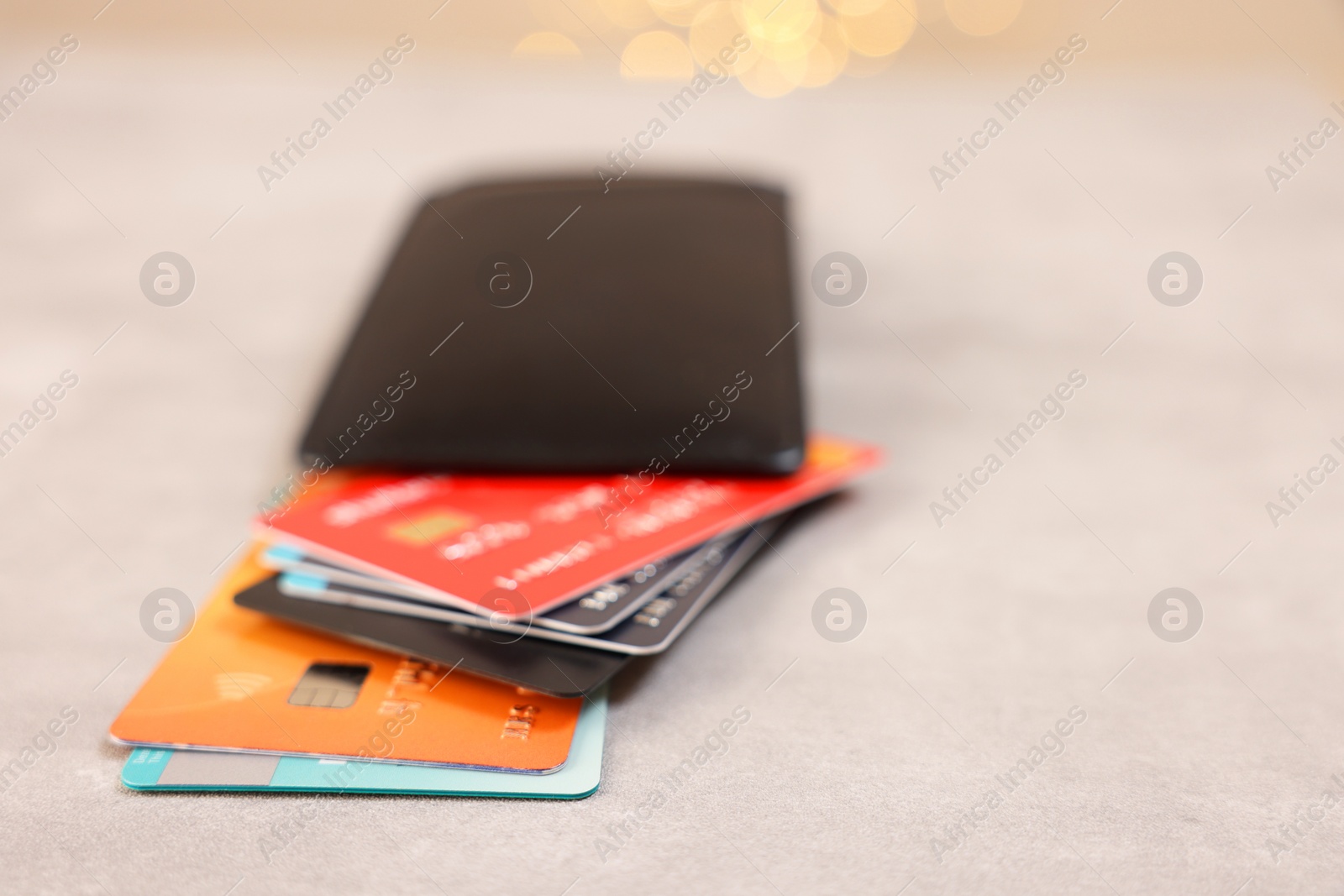 Photo of Pile of different credit cards on grey table, closeup. Space for text