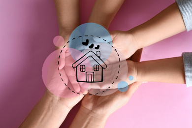 Image of Happy family holding hands and illustration of house on pink background, top view. Adoption concept