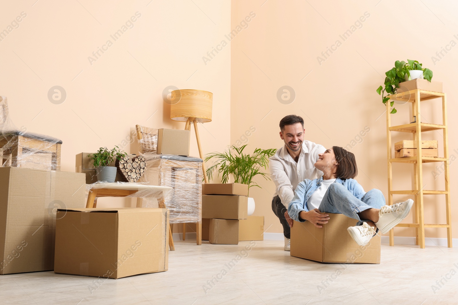 Photo of Happy couple having fun in new apartment. Moving day