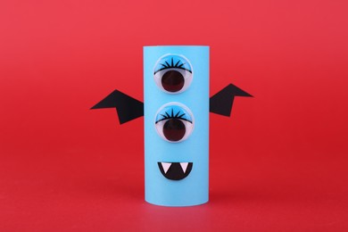 Spooky paper monster on red background. Handmade Halloween decoration