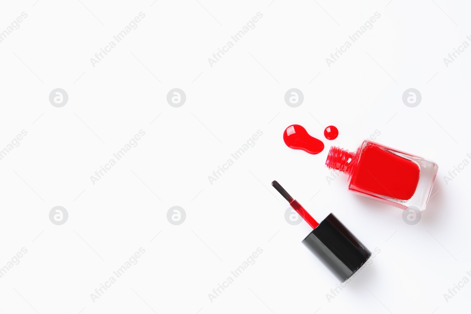 Photo of Spilled color nail polish with bottle and brush on white background, top view