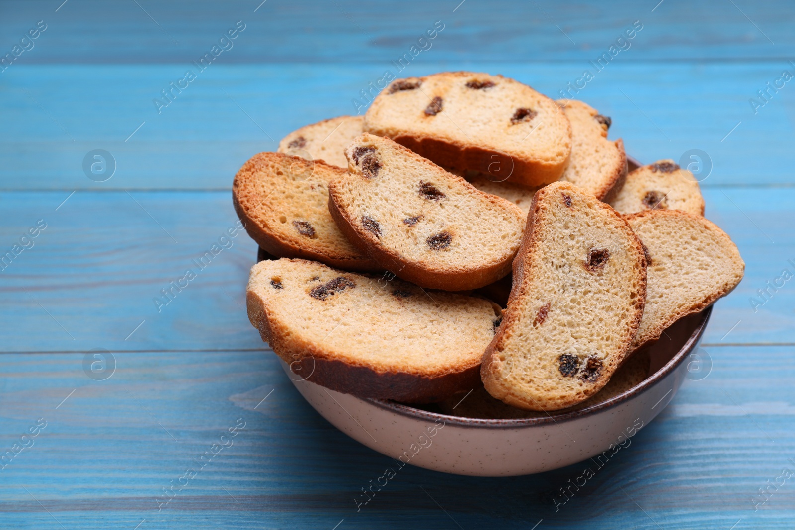 Photo of Sweet hard chuck crackers with raisins on light blue wooden table