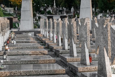 Photo of Many granite tombstones on cemetery. Funeral ceremony