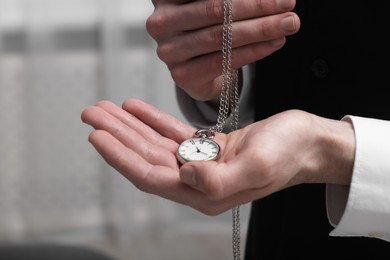 Photo of Man holding chain with elegant pocket watch, closeup. Space for text