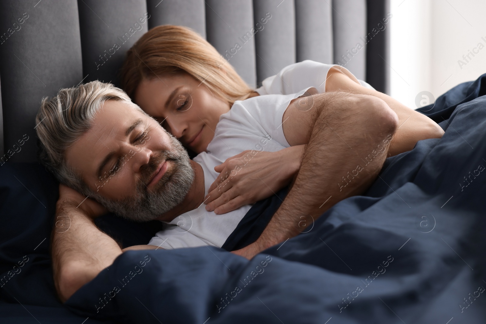 Photo of Lovely mature couple sleeping together in bed at home