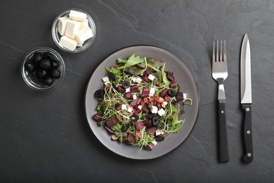 Photo of Delicious carrot salad served on black table, flat lay