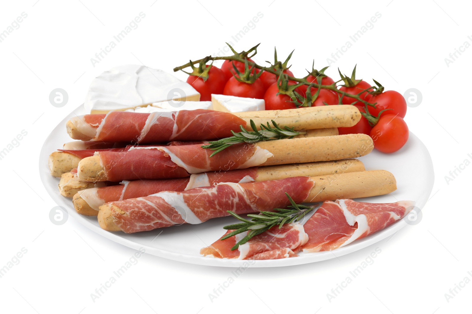 Photo of Plate of delicious grissini sticks with prosciutto, tomatoes and cheese on white background