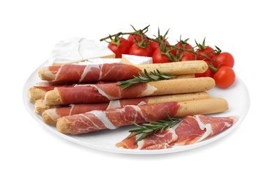 Photo of Plate of delicious grissini sticks with prosciutto, tomatoes and cheese on white background