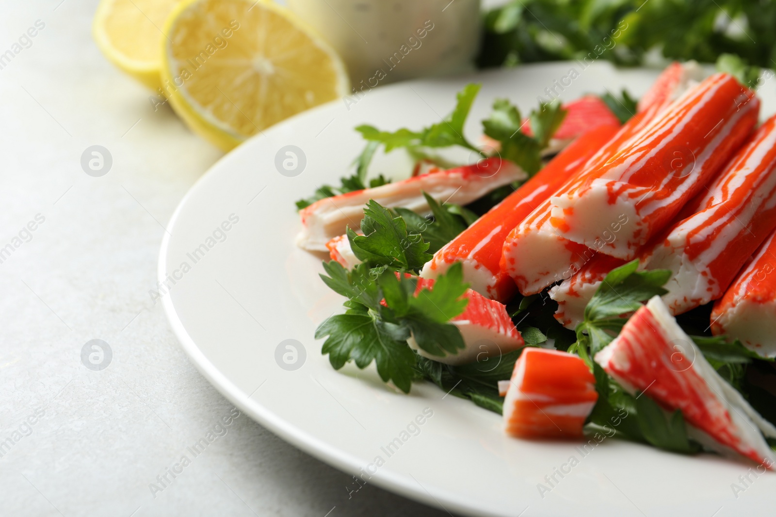 Photo of Crab sticks and parsley on light table, closeup