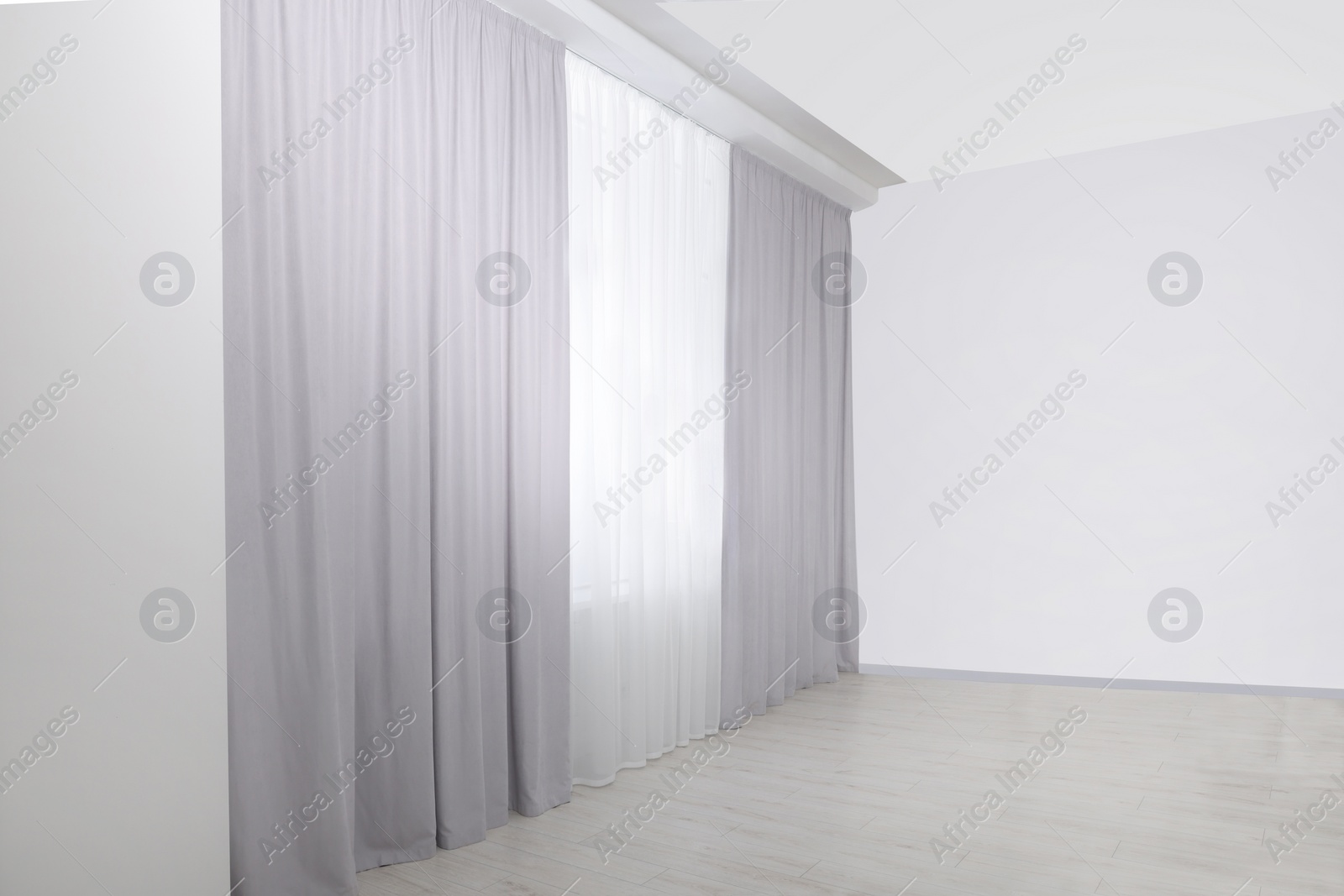 Photo of Light grey window curtains and white tulle indoors