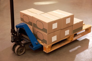 Image of Manual forklift with cardboard boxes in warehouse. Logistics concept