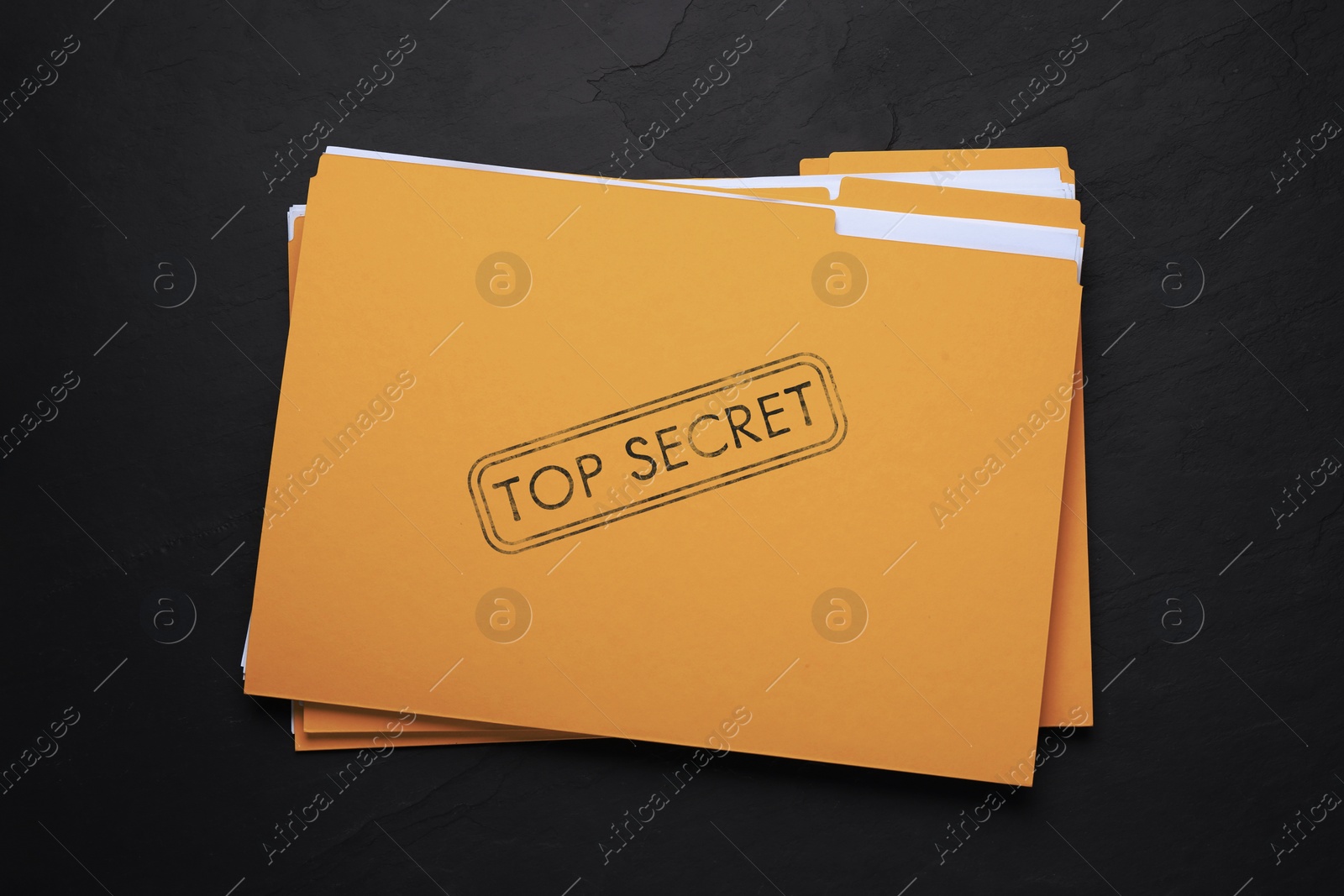 Image of Yellow file with documents and Top Secret stamp on black table, top view