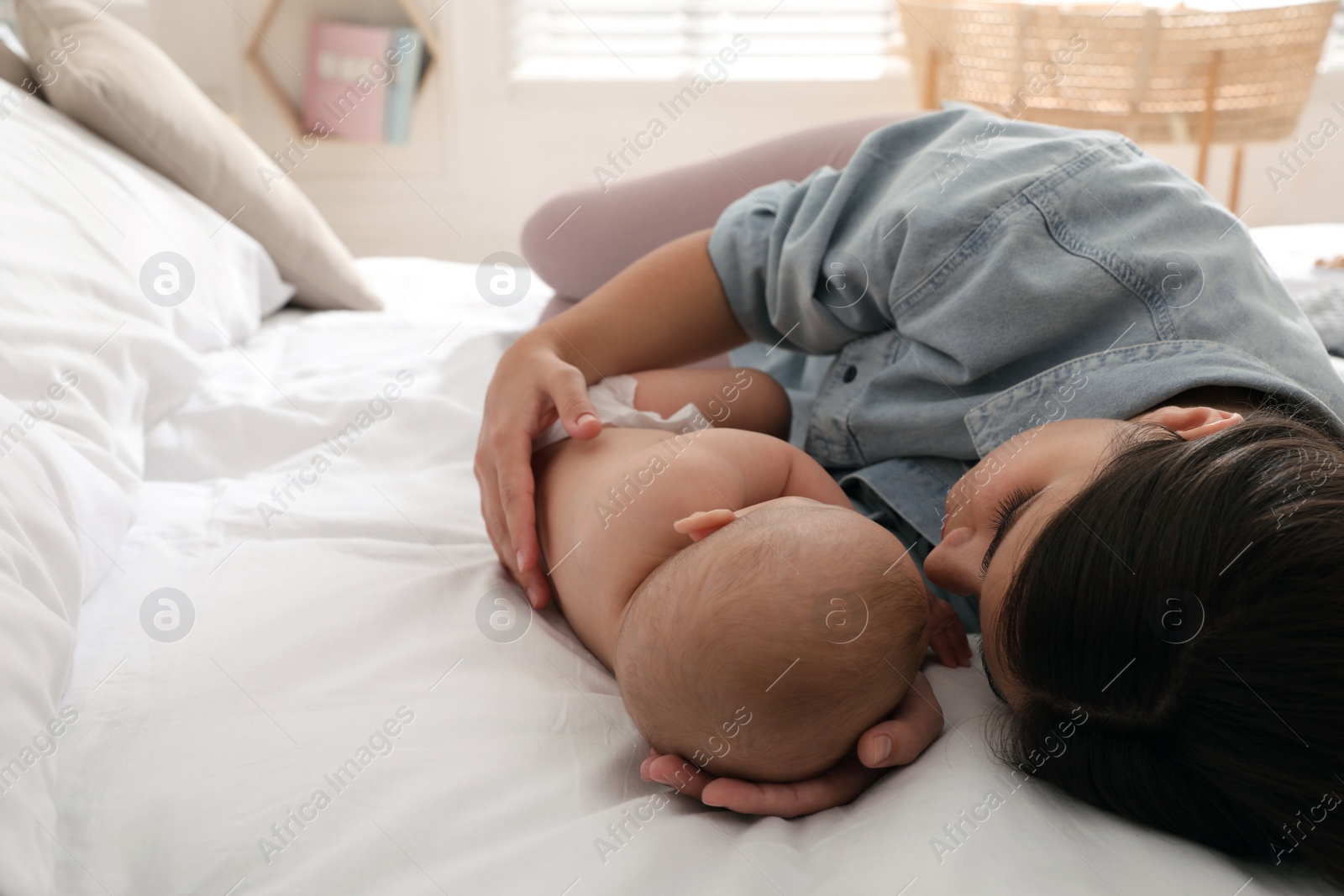 Photo of Mother with her cute baby sleeping on bed at home