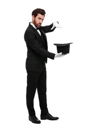 Magician showing magic trick with top hat on white background