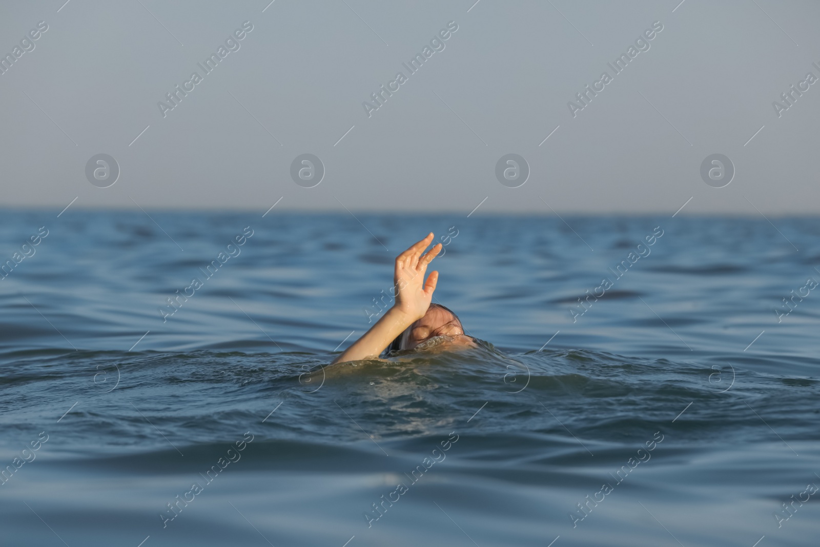 Photo of Drowning woman reaching for help in sea