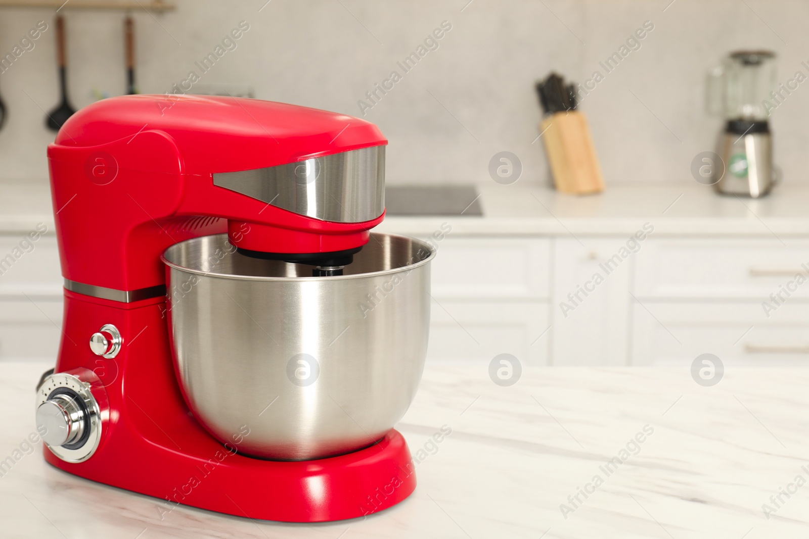 Photo of Modern red stand mixer on white marble table in kitchen, space for text