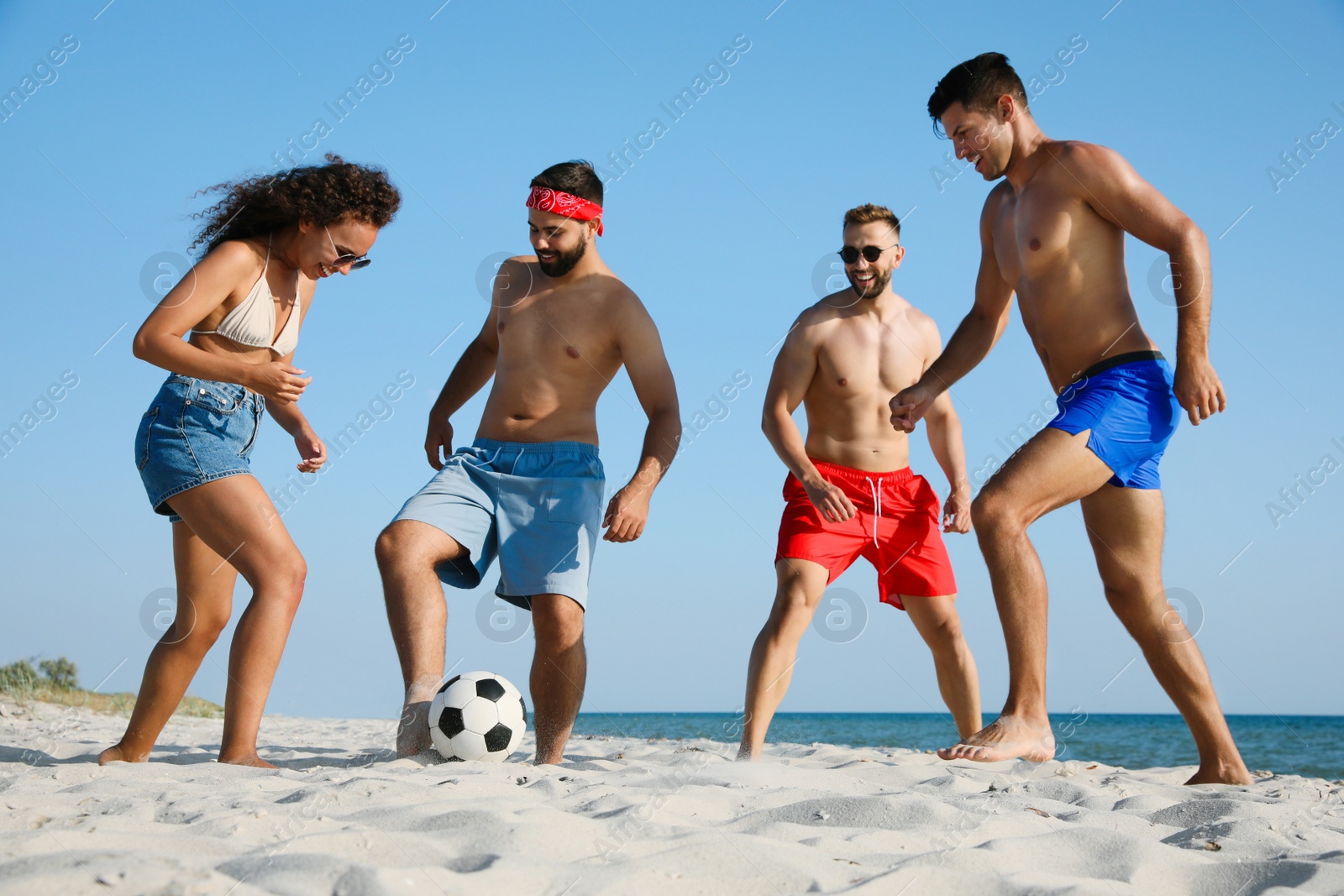 Photo of Group of friends playing football on beach