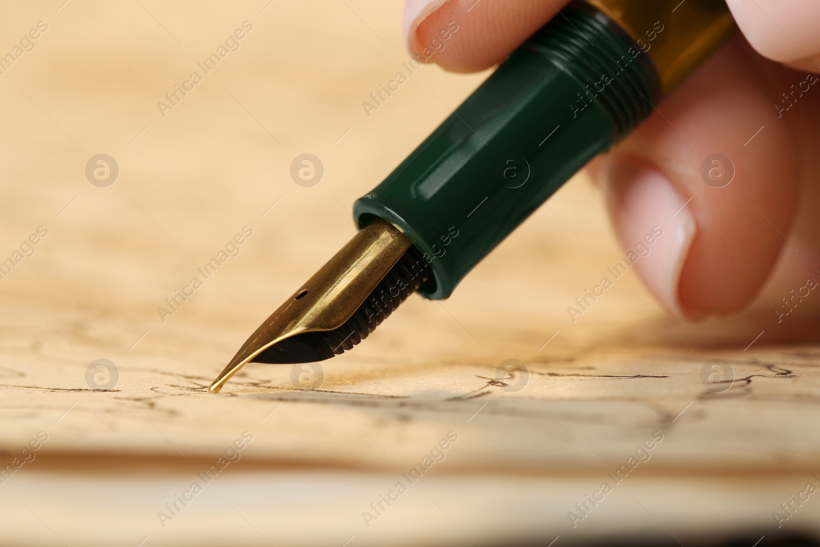 Photo of Woman writing letter with fountain pen, closeup