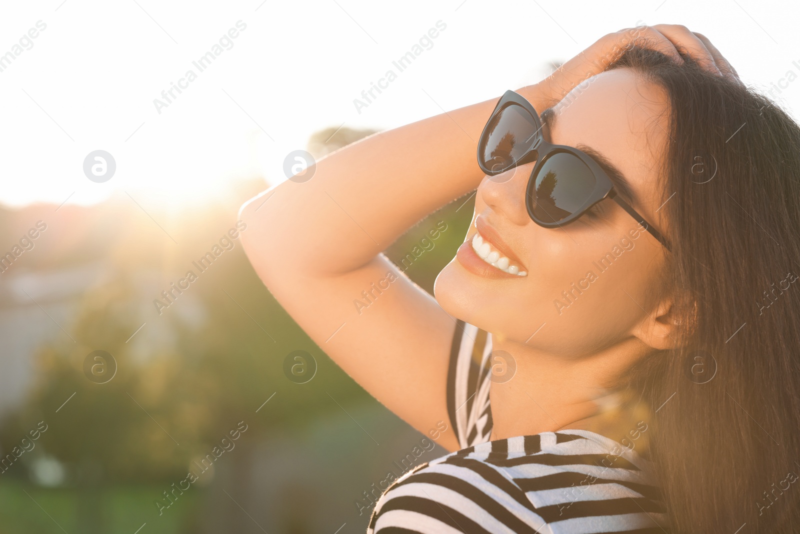 Photo of Beautiful smiling woman in sunglasses outdoors, space for text