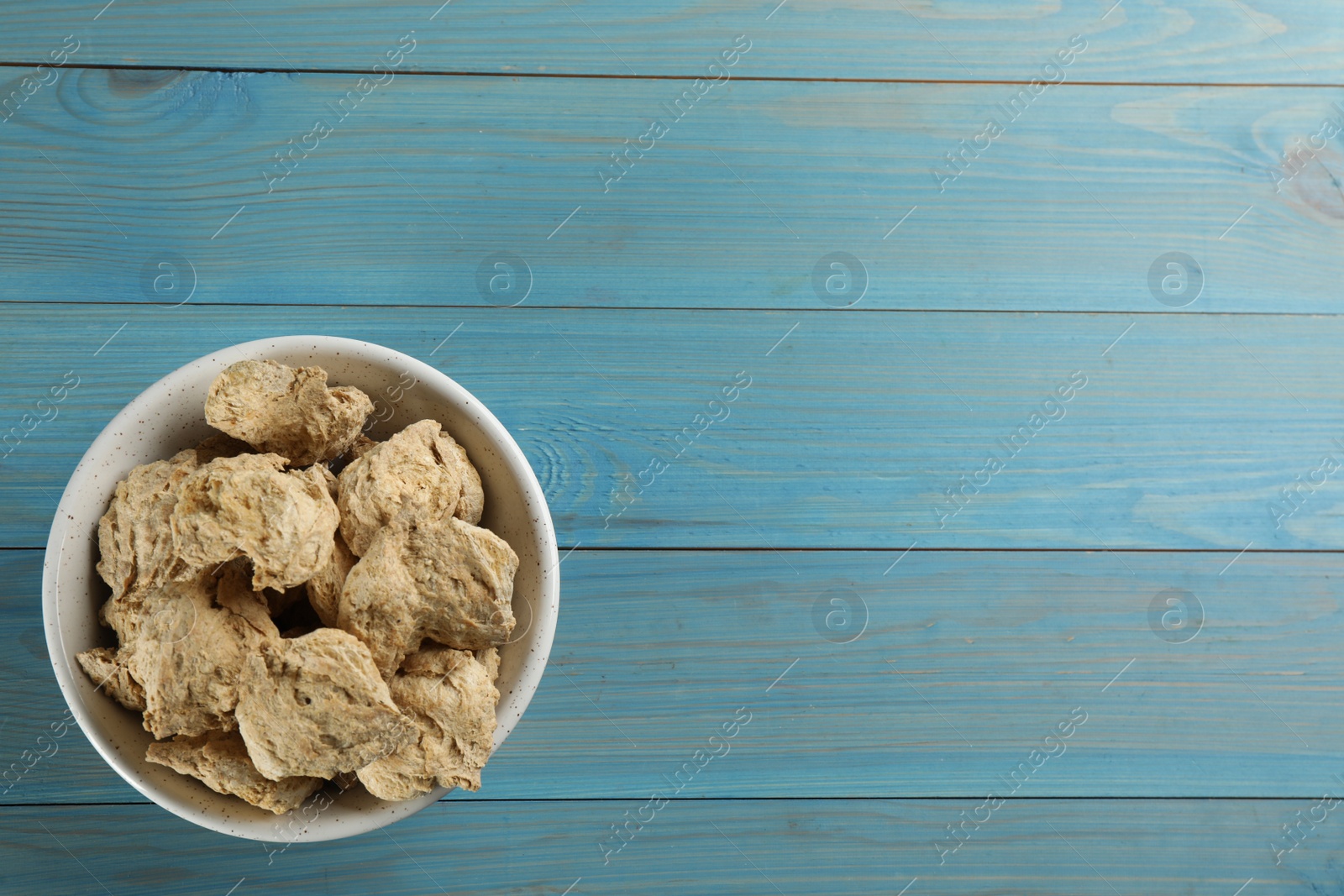 Photo of Dried soy meat on light blue wooden table, top view. Space for text