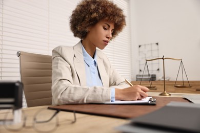 Photo of Notary with clipboard writing notes at workplace in office