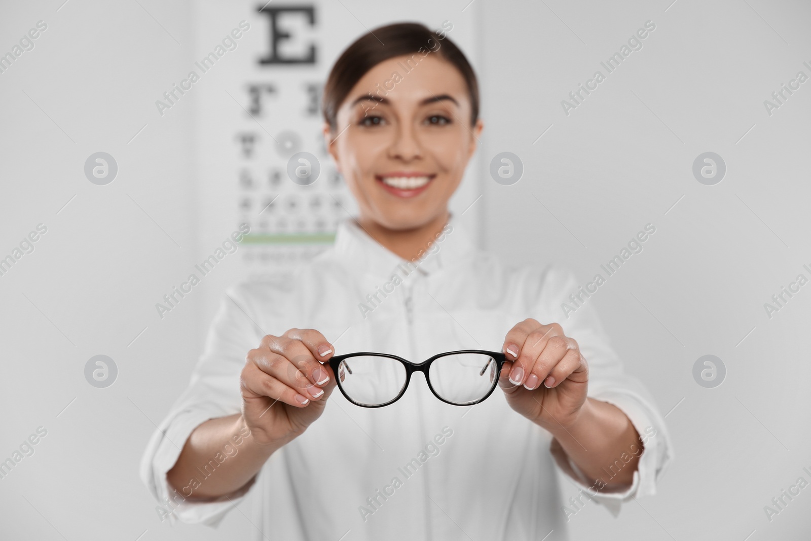 Photo of Female ophthalmologist with eyeglasses in clinic, closeup