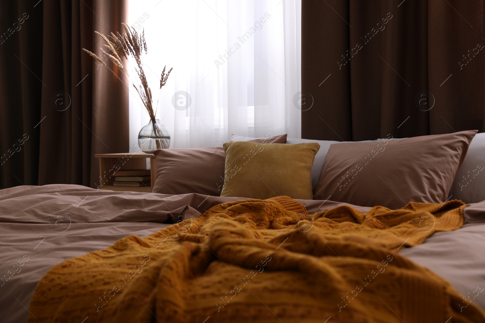 Photo of Bed with brown linens in stylish room