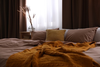 Photo of Bed with brown linens in stylish room