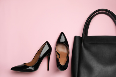 Photo of Stylish woman's bag and shoes on pink background, flat lay. Space for text