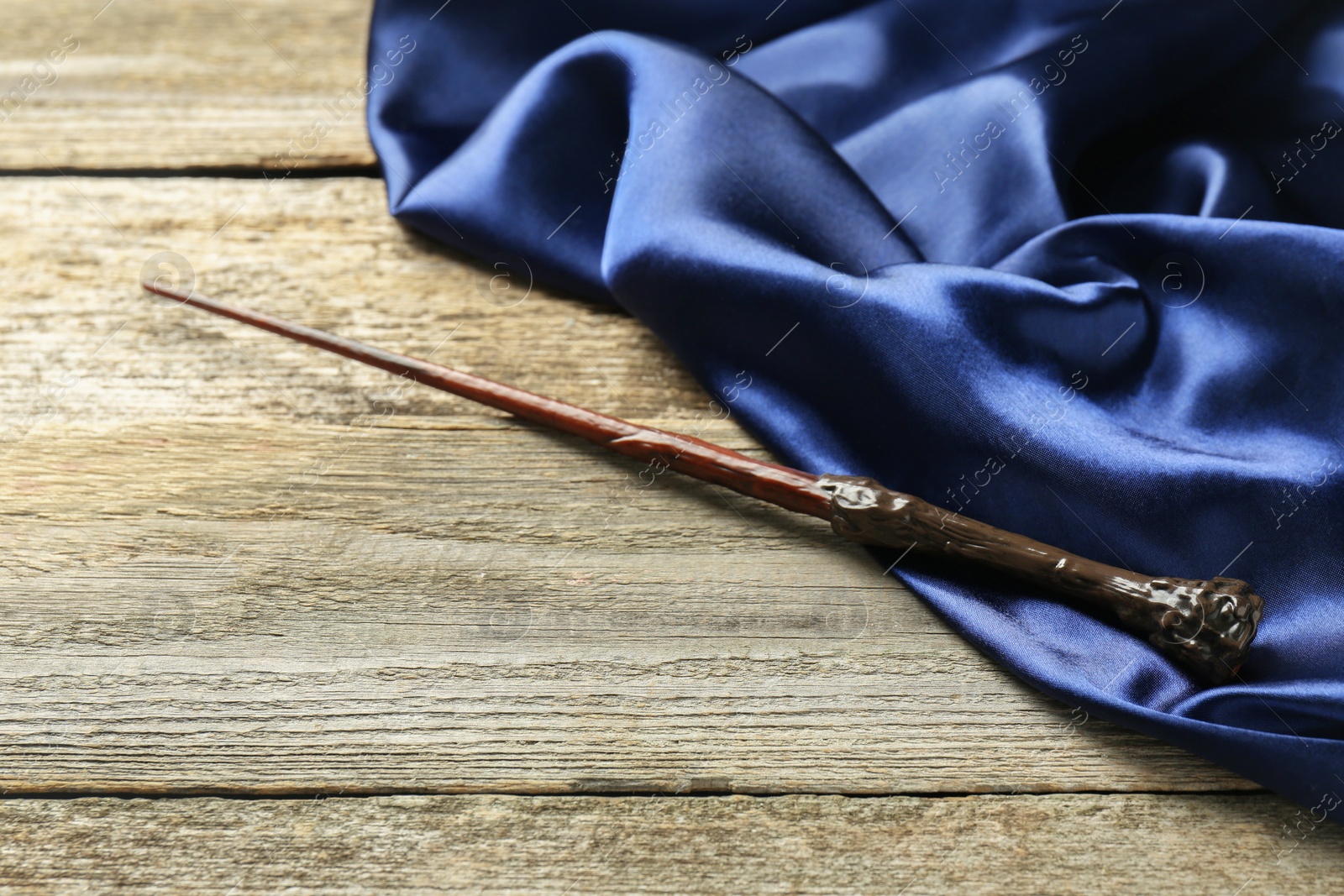 Photo of Old magic wand and fabric on wooden table