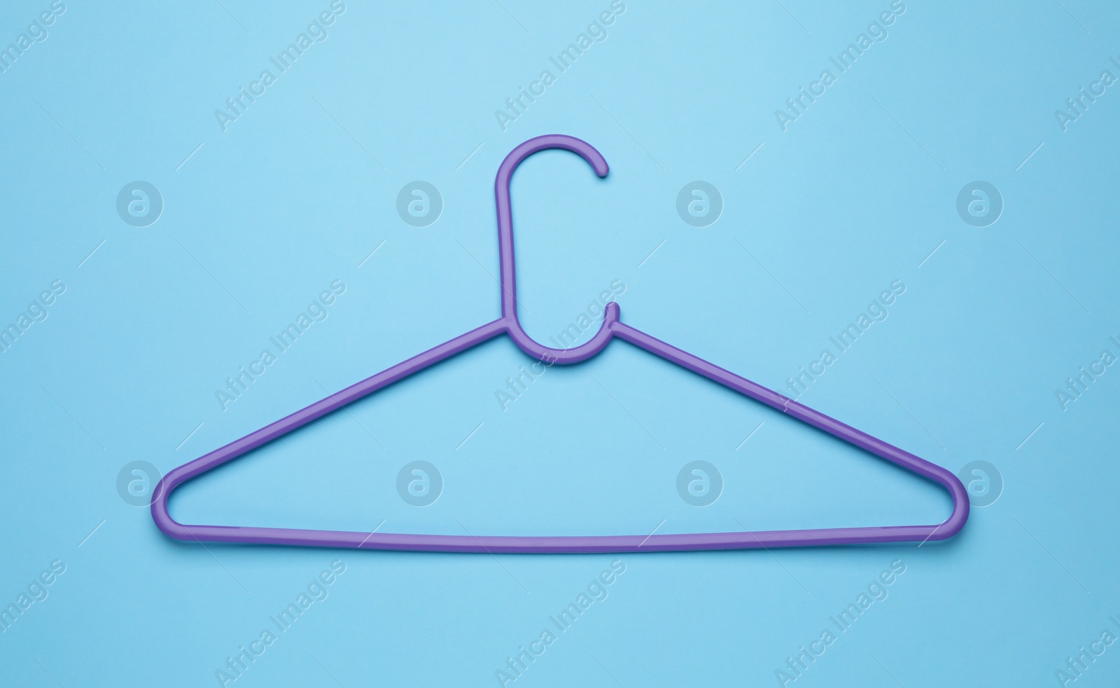 Photo of Empty clothes hanger on light blue background, top view