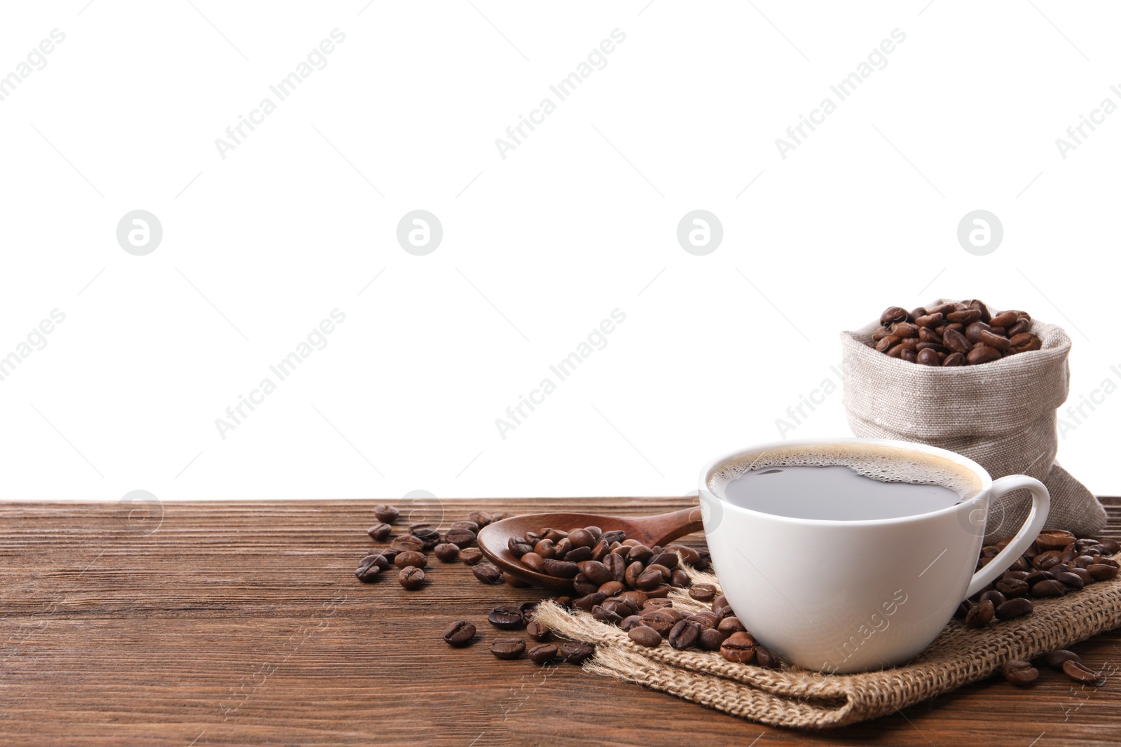Photo of Cup of aromatic hot coffee and beans on wooden table against white background. Space for text