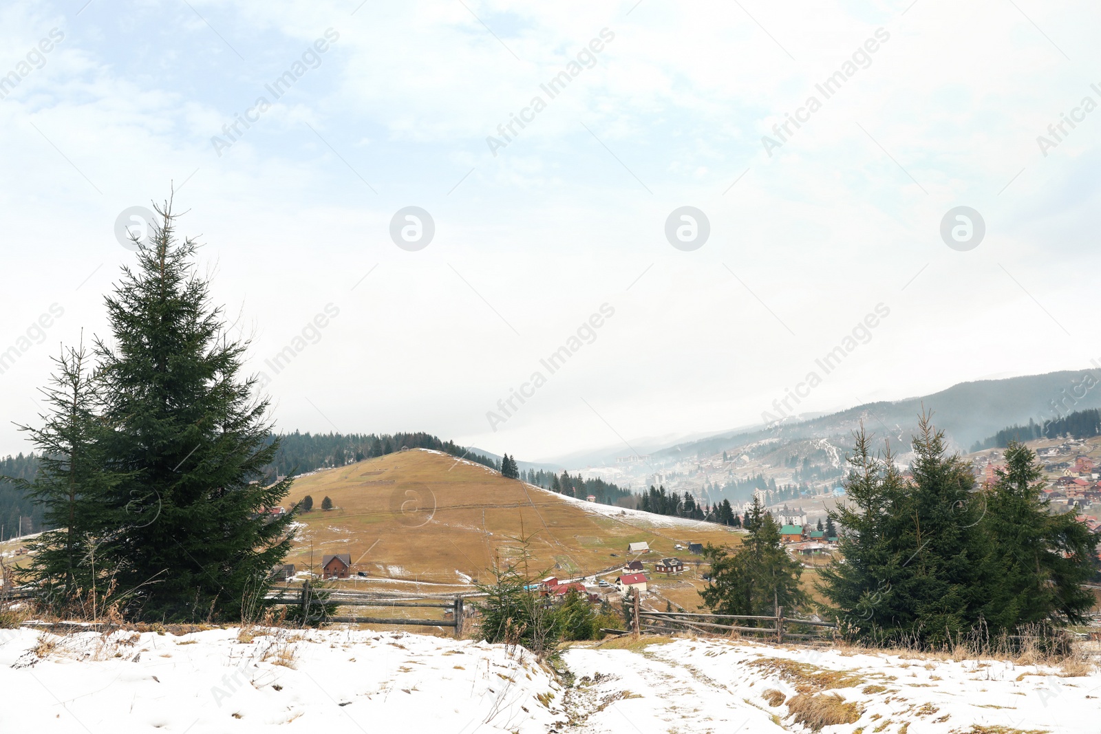 Photo of Beautiful winter landscape with buildings and forest on hills