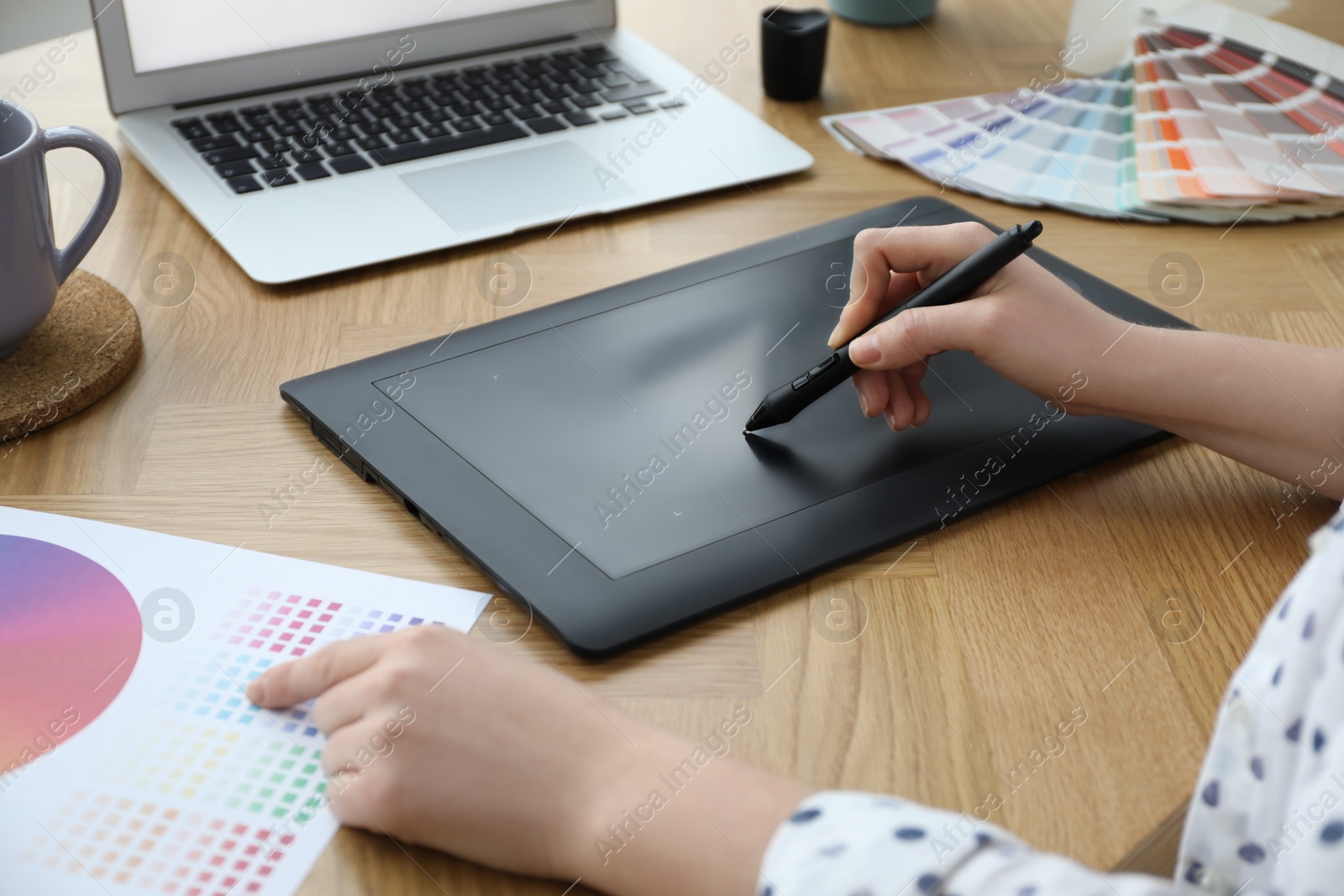 Photo of Professional designer with graphic tablet at wooden table, closeup