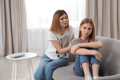 Worried mother talking to her teenager daughter at home