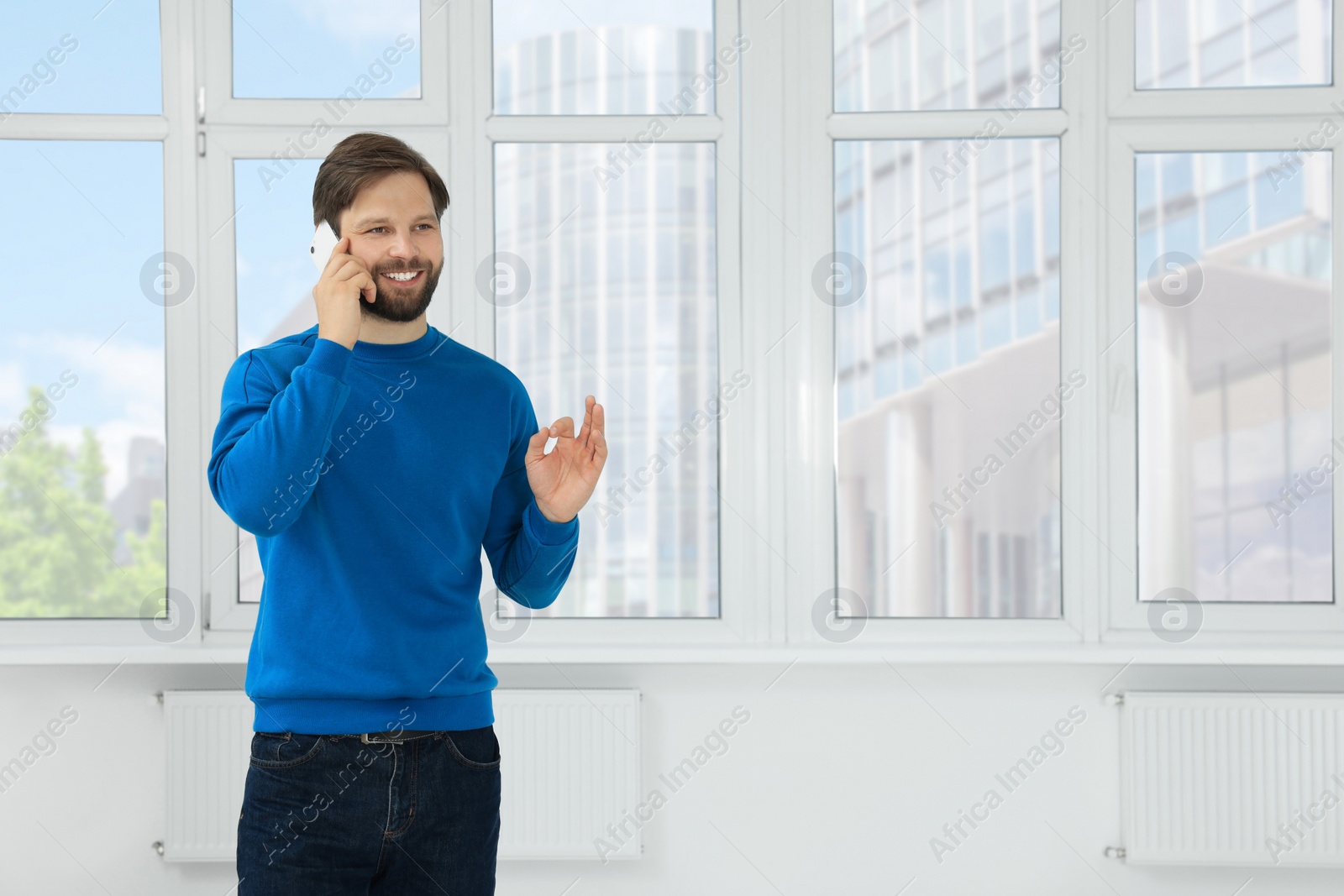 Photo of Man in casual clothes talking on phone indoors, space for text