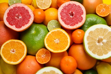 Different ripe citrus fruits as background, top view