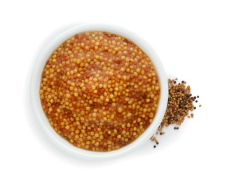 Fresh whole grain mustard in bowl and dry seeds isolated on white, top view