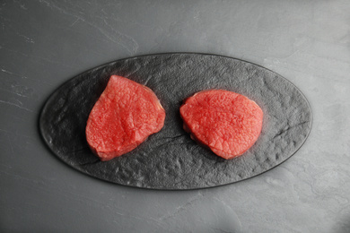 Photo of Fresh raw beef cut on black table, top view