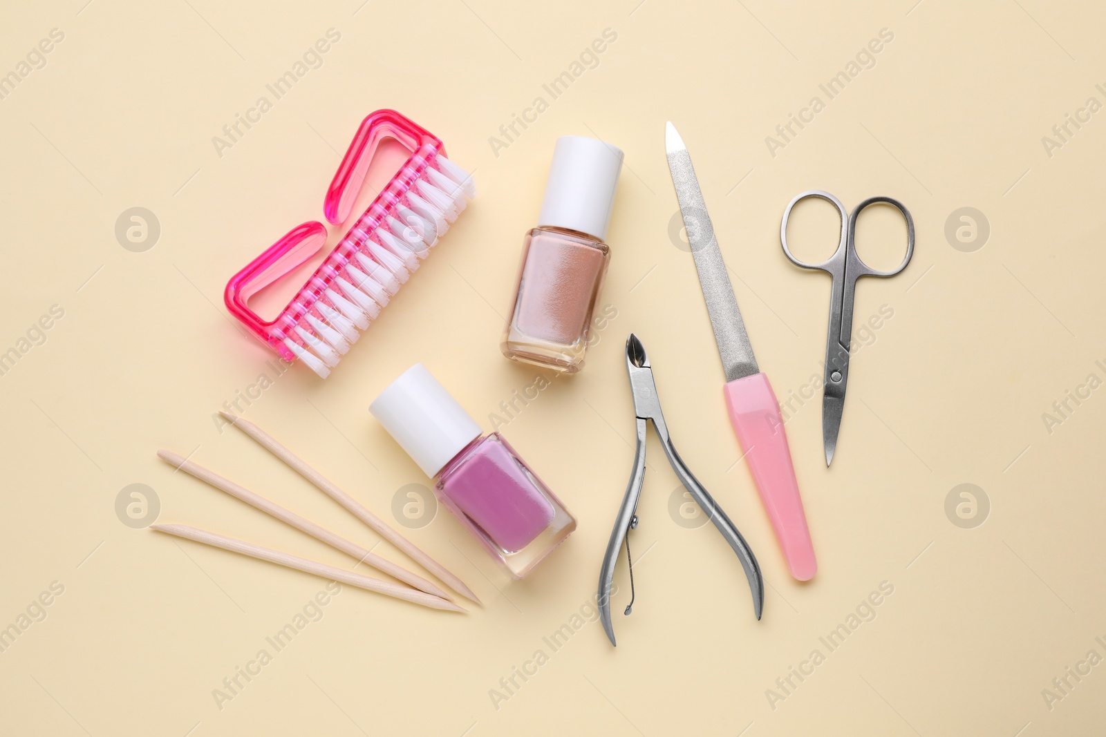 Photo of Set of pedicure tools on beige background, flat lay