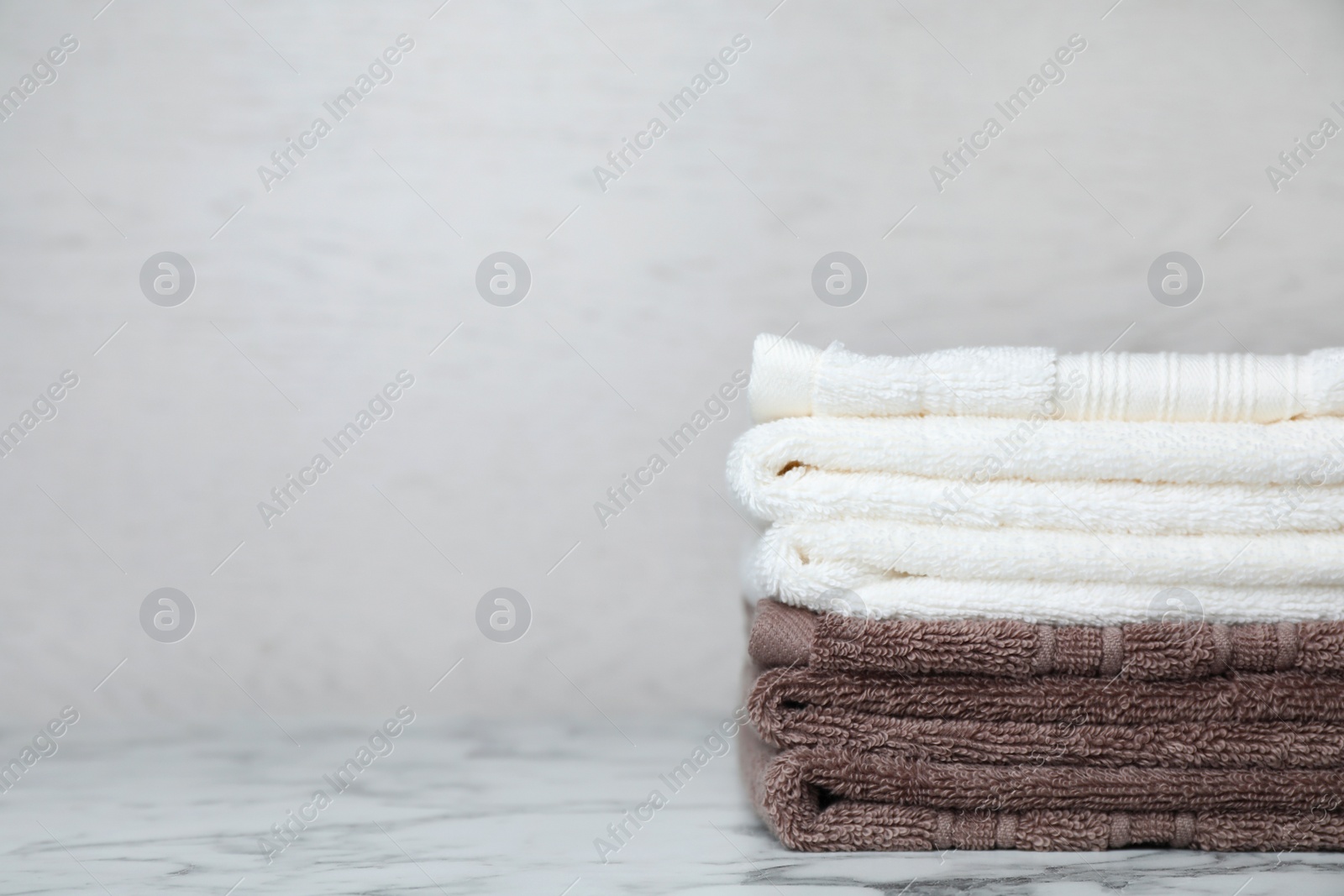 Photo of Stack of soft bath towels on table. Space for text