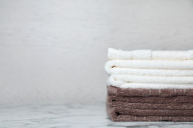 Photo of Stack of soft bath towels on table. Space for text