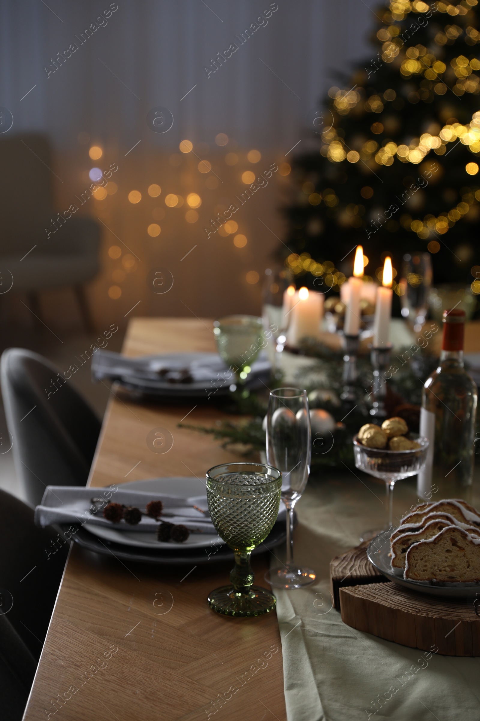 Photo of Christmas table setting with festive decor and dishware indoors