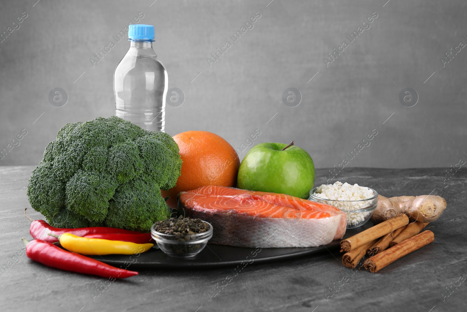 Photo of Metabolism. Different food products on grey table, space for text