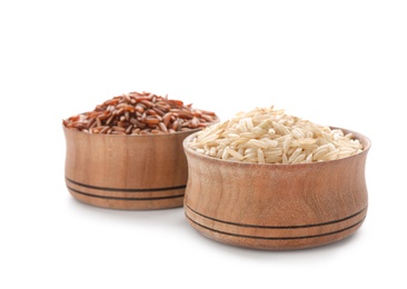 Wooden bowls with brown rice on white background