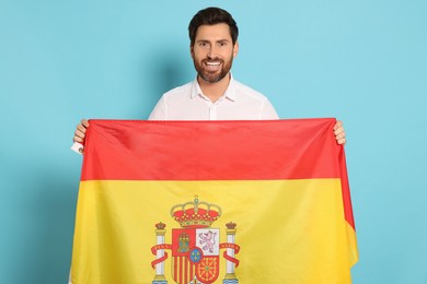Photo of Man with flag of Spain on light blue background